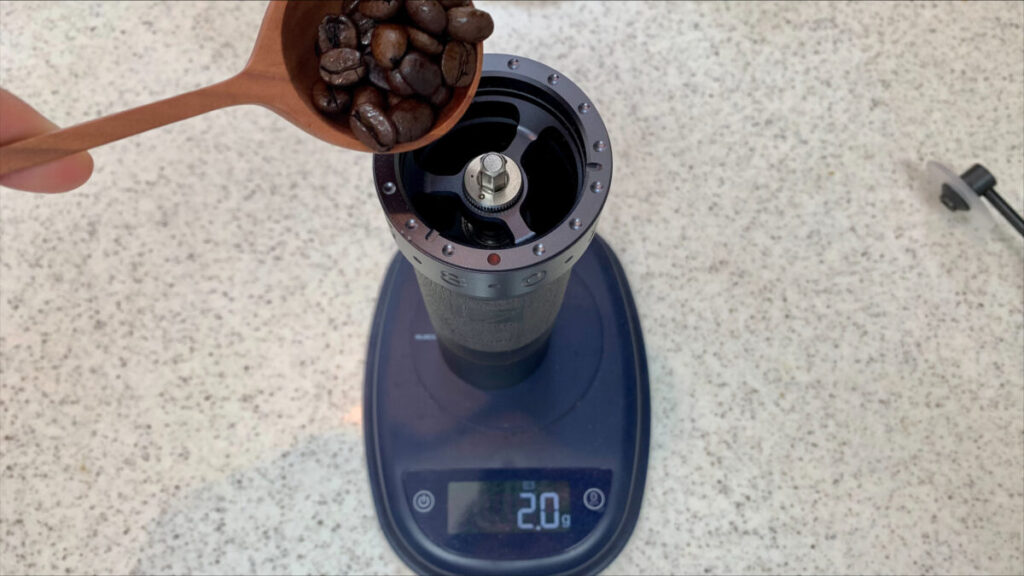 コーヒーミルにコーヒー豆を入れている写真